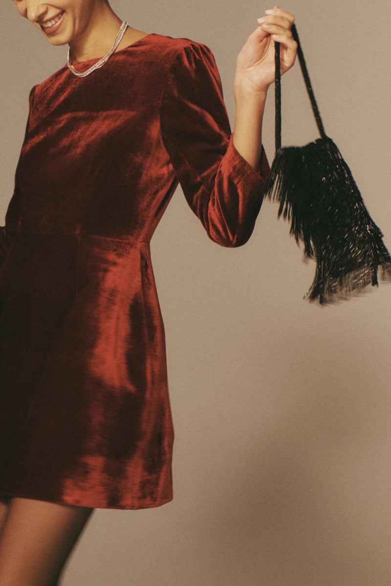 Black Beaded Josephine Mini Bag with playful fringes and intricate beading, adding a classic, effortless touch to the velvet dress for a high-end, fun look.
