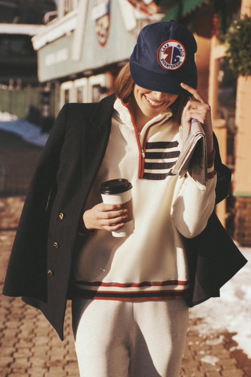Person outside in casual wear, sporting the Navy Diana Blazer over shoulders. The blazer's classic, high-end style exudes effortless, fun elegance with its oversized, tailored fit.