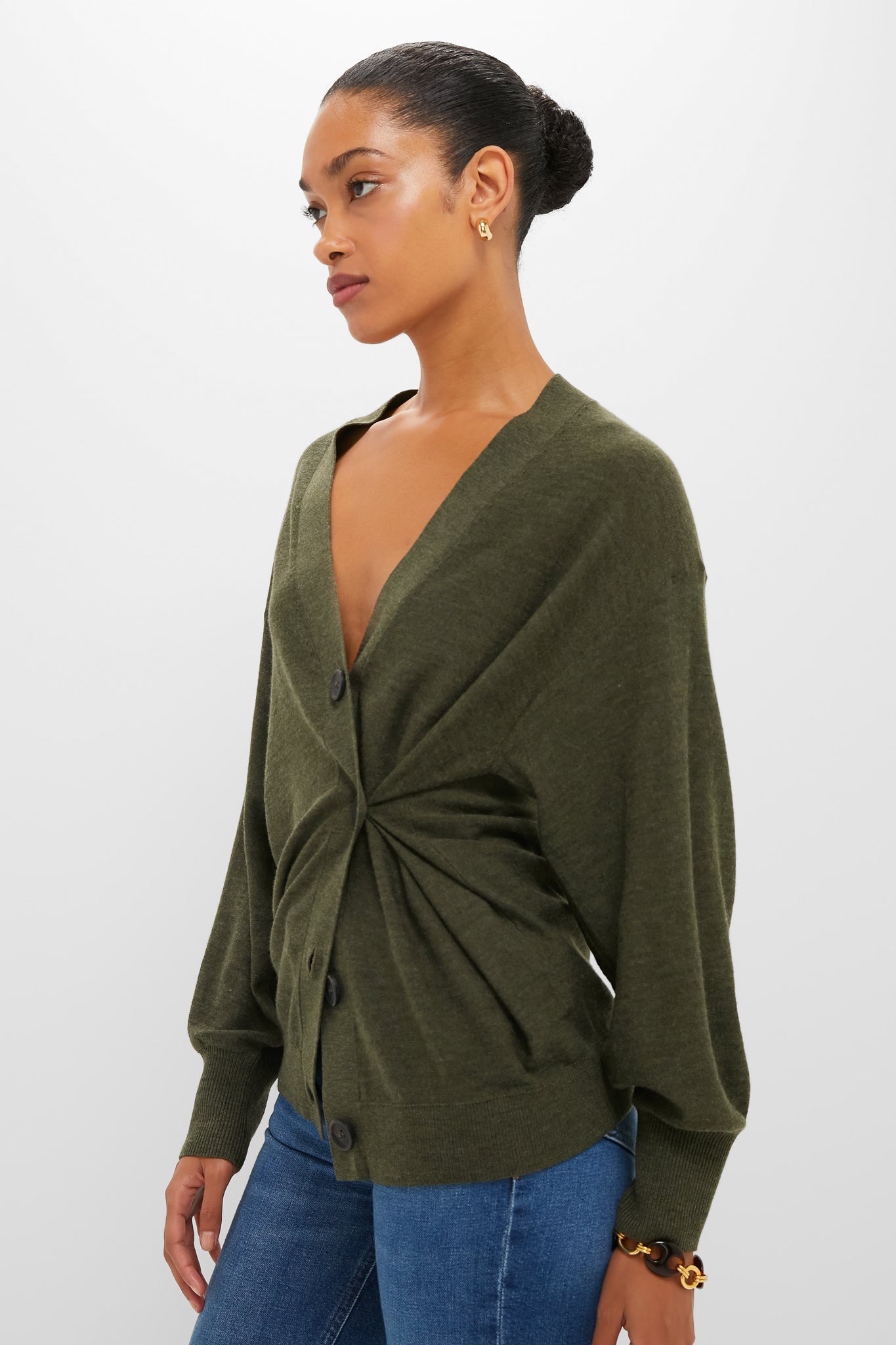 Model wearing the classic Olive Drippy Tissue Cardigan, effortlessly styled with a twisted-gather waist detail, paired with jeans and gold accessories for a high-end, fun look.