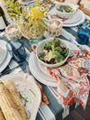 Table set for dinner with a salad and corn on serveware 