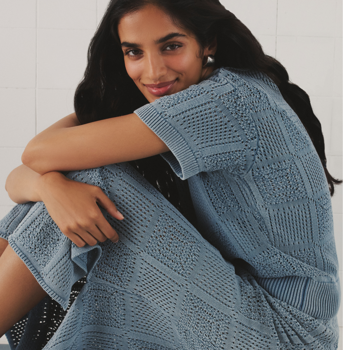 Woman in a blue crochet matching set. 