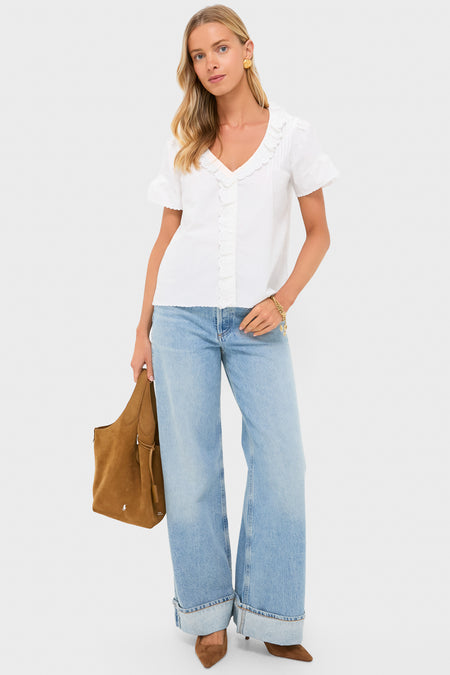 Model showcasing the Vintage White Ezra Blouse, featuring scalloped lace trims and short flutter sleeves. Styled with high-waisted jeans, exuding an effortless, classic elegance.