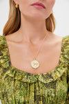 Classic Gold Courage Horse JW Original Pendant Coin on green ruffled blouse, showcasing an effortless and fun high-end style with a textured horse design and star details.