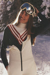 Young woman in a winter setting wearing the classic Chevron Johnny Turtleneck Sweater, styled effortlessly with ski gear, embodying fun and high-end winter sports fashion.