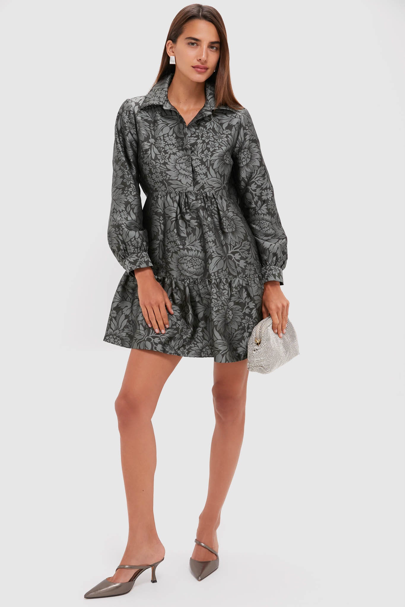 Model wearing the classic Emerald Mirasol Jacquard Alette Dress with a fun botanical pattern, effortless tiered skirt, and high-end metallic accessories, exuding confidence and grace.