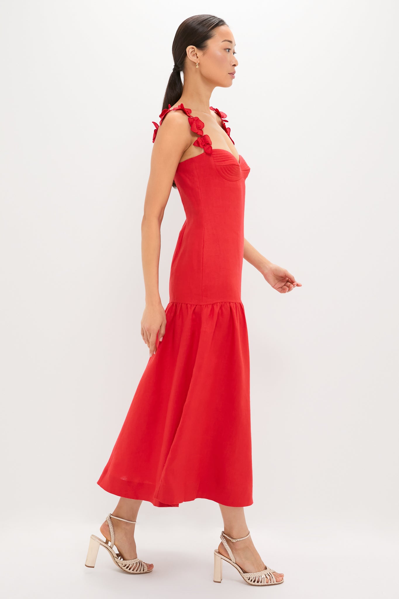 Model in the Red Ser Arte Embellished Maxi Dress, featuring a classic sweetheart neckline, flared skirt, and flower-tied straps, paired with effortless, high-end block-heeled sandals.