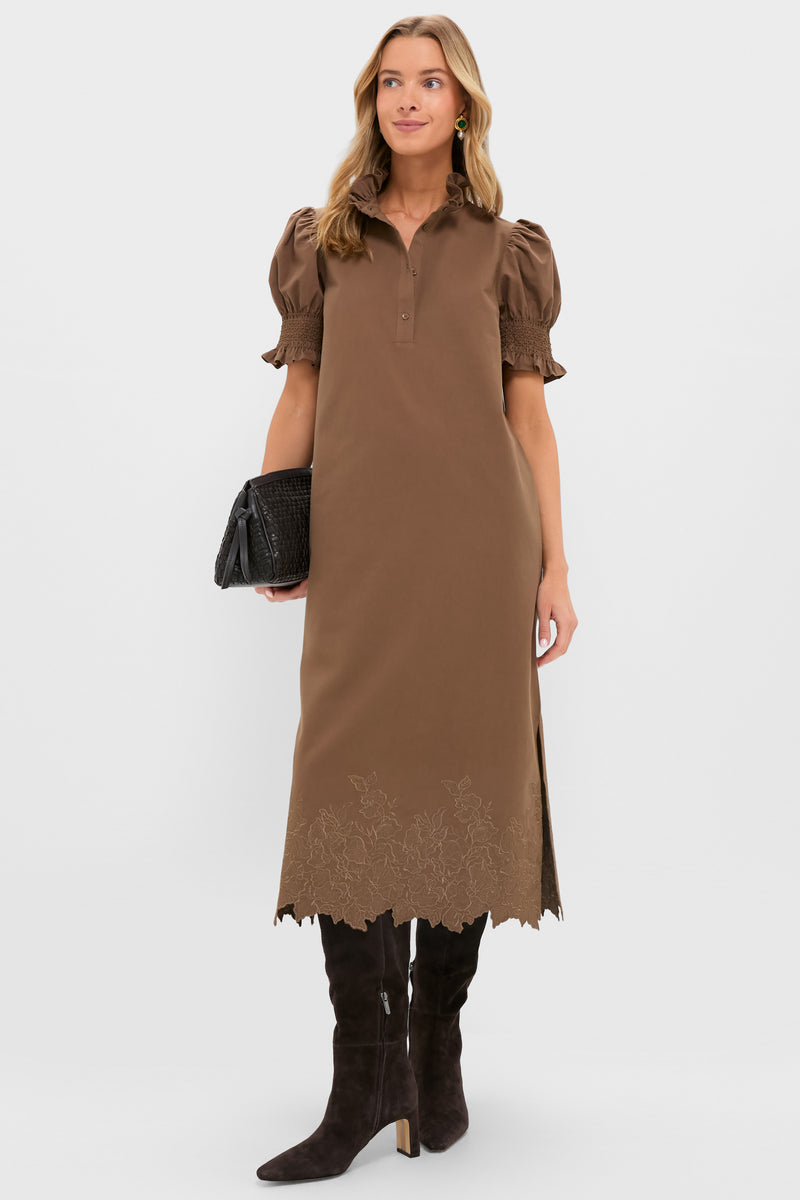 Model wearing the classic Mocha Embroidery Eliza Midi Dress with ruffled collar, puff sleeves, and embroidered hem; styled with high-end suede boots and a woven clutch.