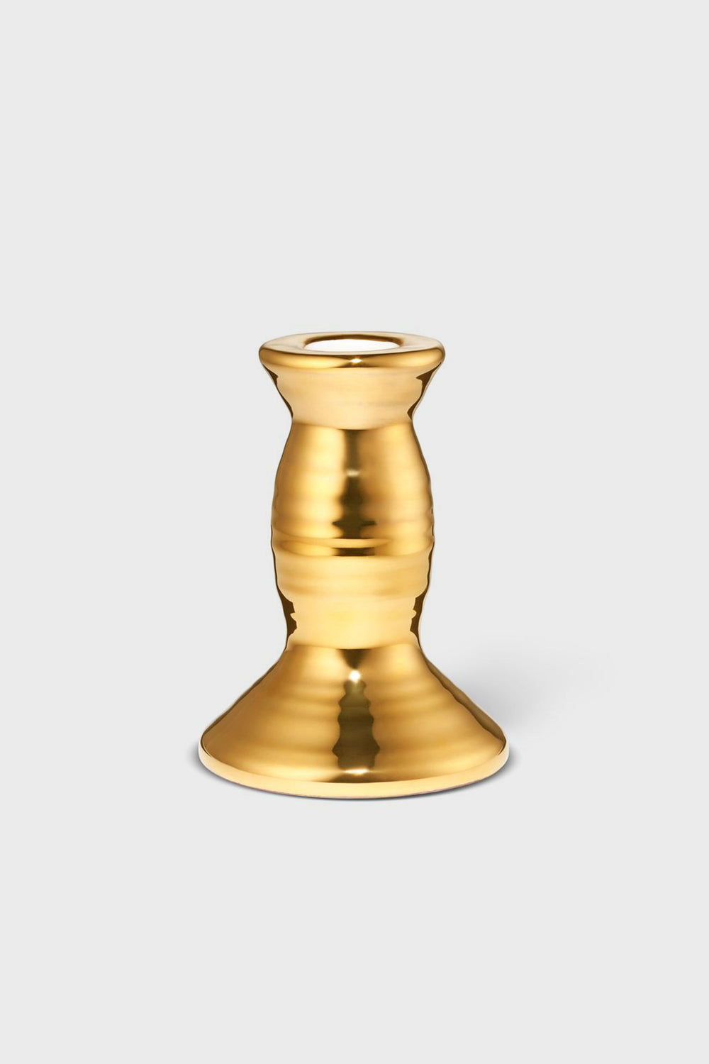 The AERIN gold-colored metallic candlestick holder features a wide base and rounded, tapered middle, adding artisanal elegance and craftsmanship to your home decor.