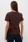 Woman in an effortlessly cool Bronze Metallic Fringe Francie Blouse, featuring a classic back zip and fun fringe hem, paired with dark jeans.