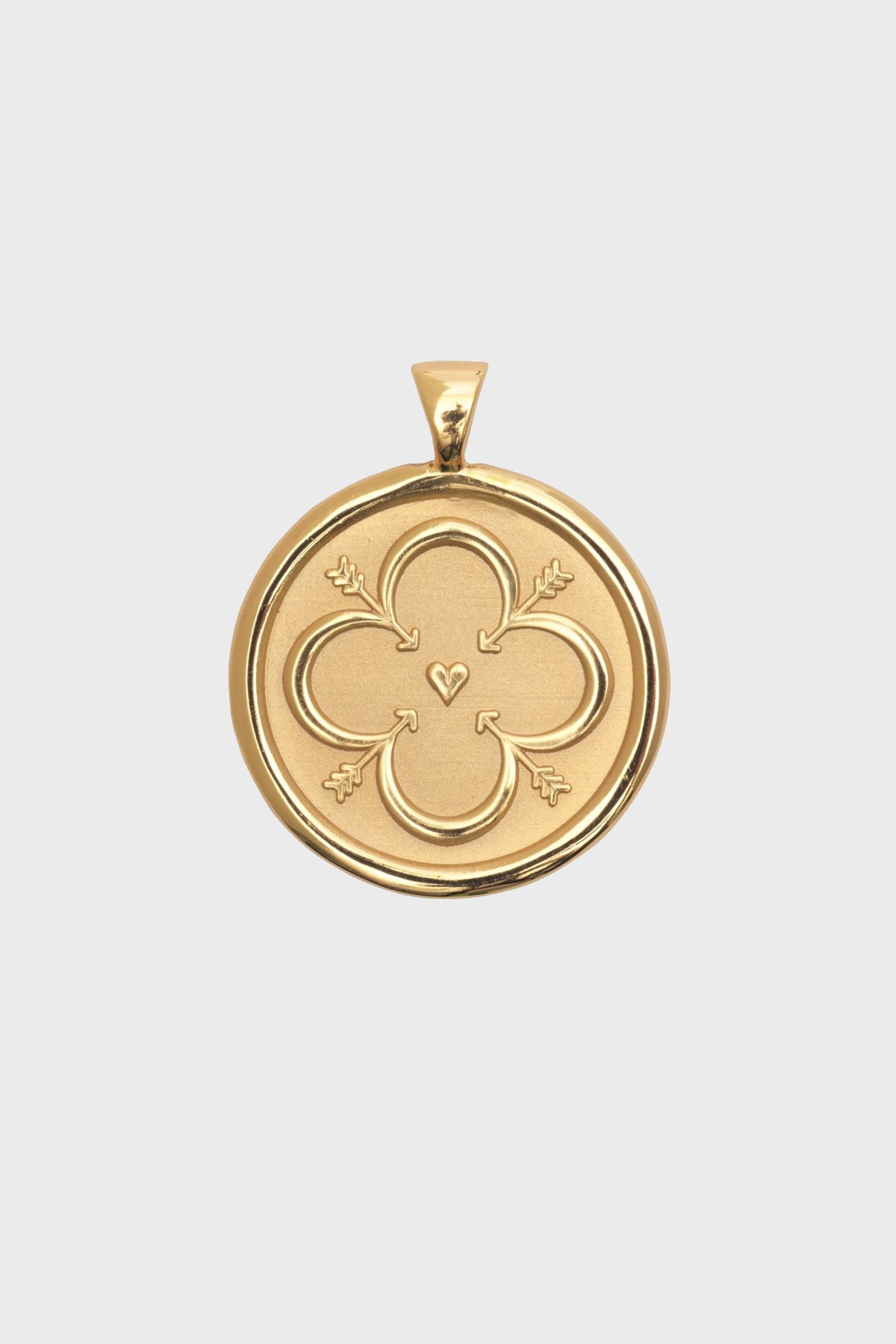 Jane Win gold oval pendant featuring an engraved quatrefoil design with a small heart at the center and decorative flourishes, crafted in a 14k gold plated finish.