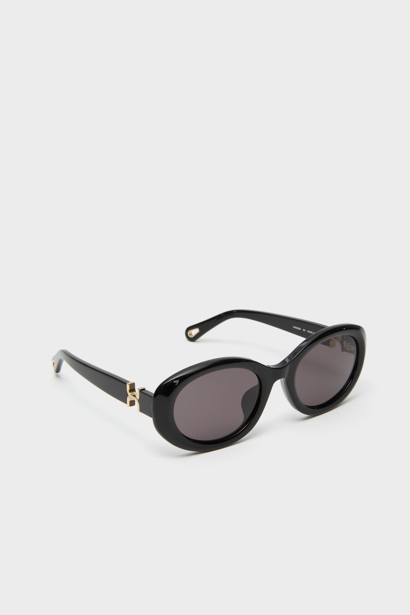 Shiny Solid Black Marcie Sunglasses showcase a classic, effortless design with glossy oval frames and gold-tone hinges, embodying fun and high-end sophistication.