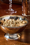 Graham 6 Cocktail Bowl: A classic, high-end hammered-metal bowl filled with pistachios, embodying effortless elegance and fun, perfect for elevating any cocktail hour.