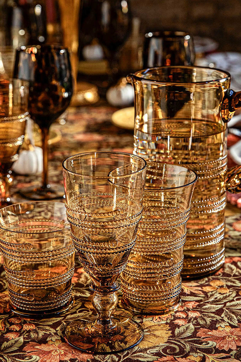 Amber Ella Goblet, a high-end, mouth-blown masterpiece, effortlessly sparkles with its ribbed, beaded glass design, perfect for adding classic elegance to any fun occasion.