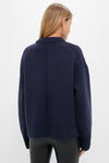 Back view of the Navy Genevieve Cashmere Wool Blend Crewneck Sweater, showcasing its classic, chunky knit and boxy fit, paired with black leather-look pants.