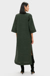 Woman wearing the classic Metallic Green Plaid Indy Maxi Dress with elbow-length sleeves and knee-high boots, exuding effortless style and high-end sophistication.