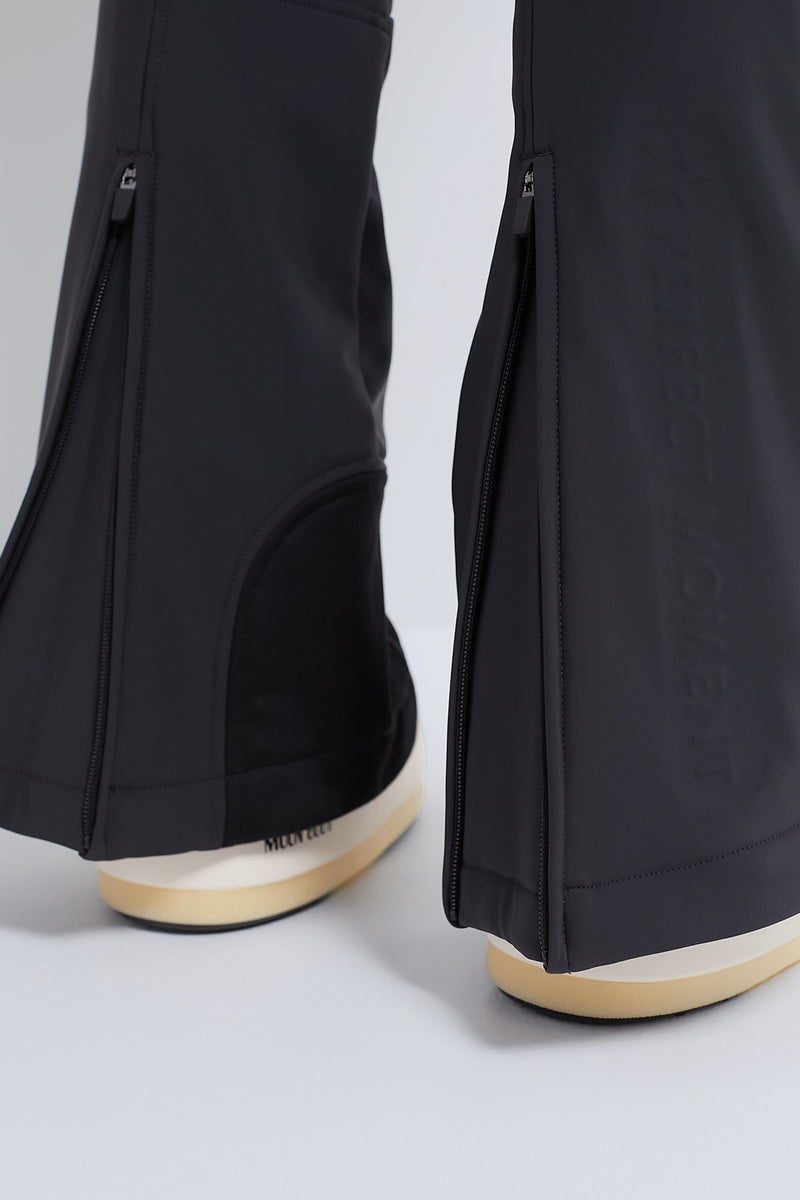 Close-up of classic Black Aurora High Waist Ski Pant with zippers at hems, showcasing effortless style and high-end, fun design with cream-and-beige platform shoes.