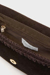 Close-up view of the open interior of a black Caterina Bertini handbag, featuring a zippered pocket, brown lining, and the Caterina Bertini brand label.