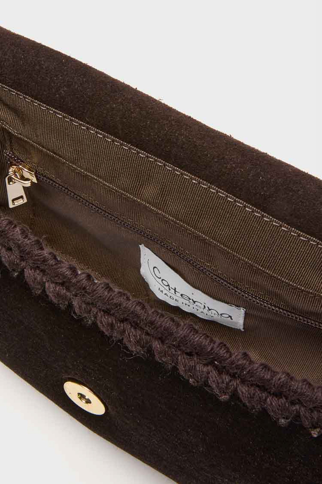 Close-up view of the open interior of a black Caterina Bertini handbag, featuring a zippered pocket, brown lining, and the Caterina Bertini brand label.