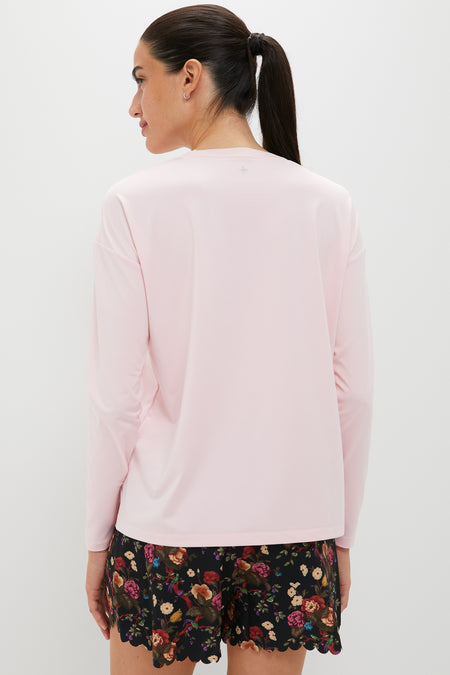 Back view of a woman in a classic, effortless Pink Long Sleeve Performance Jersey Ryan Boyfriend Tee, paired with floral-patterned shorts, embodying fun and high-end style.