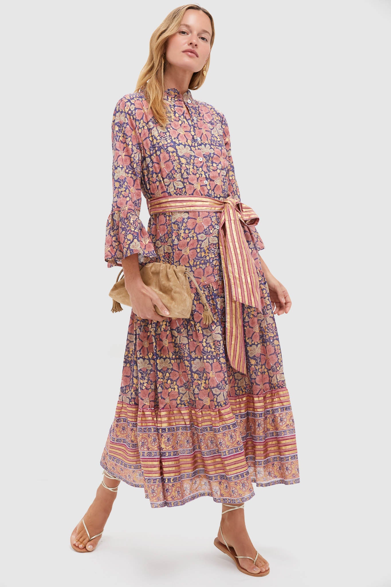 Woman models the Matera Navy Ruffle Collar Bell Maxi Dress, featuring classic floral prints, an effortless tiered skirt, and a fun, high-end sash belt.