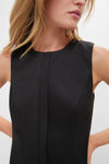 Close-up of a woman in a classic, effortless Black Mixed-Media Coco Maxi Dress with a textured tunic-style bodice and vertical seam detail, embodying high-end, fun sophistication.