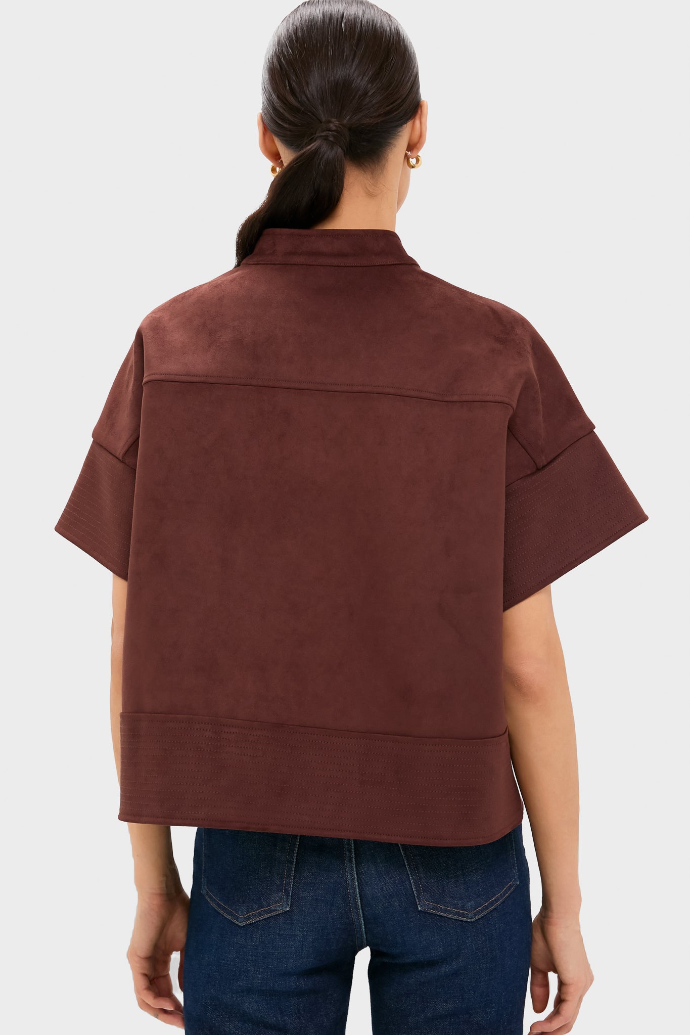 Back view of a person wearing the Ganache Vegan Suede Trapunto Stitch Sofia Shirt, showcasing its classic, effortless boxy silhouette with trapunto stitched details, paired with dark jeans.
