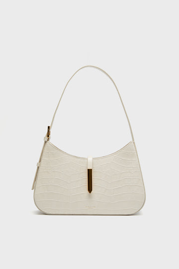 Demellier cream-colored croc effect bag with gold-tone hardware, single top handle, and minimalist design.