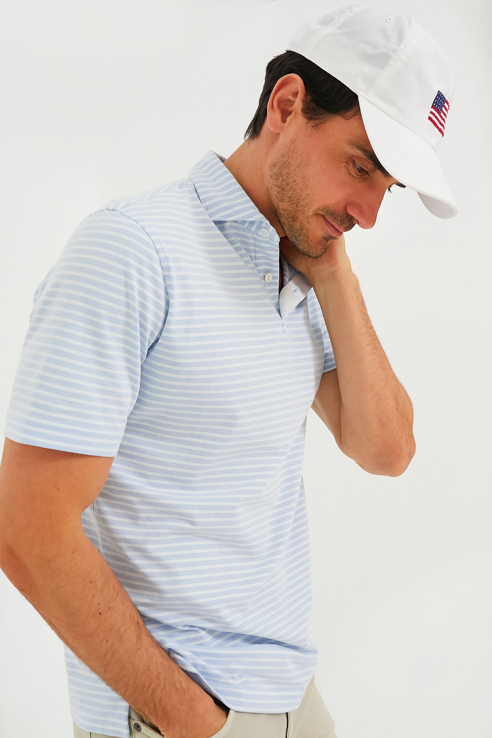 A man in a white hat wears a Peter Millar Oxford pique knit Pima cotton polo.