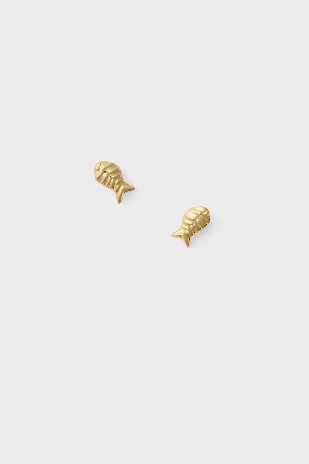 A pair of small gold fish earrings with hypoallergenic titanium posts.