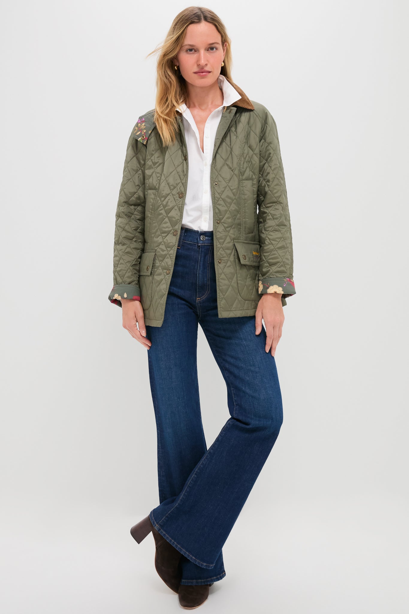 Woman wearing Zoe Gigi High Rise Skinny Flare jeans, styled with a quilted jacket and ankle boots, embodying an effortless, classic look for fun, high-end style.