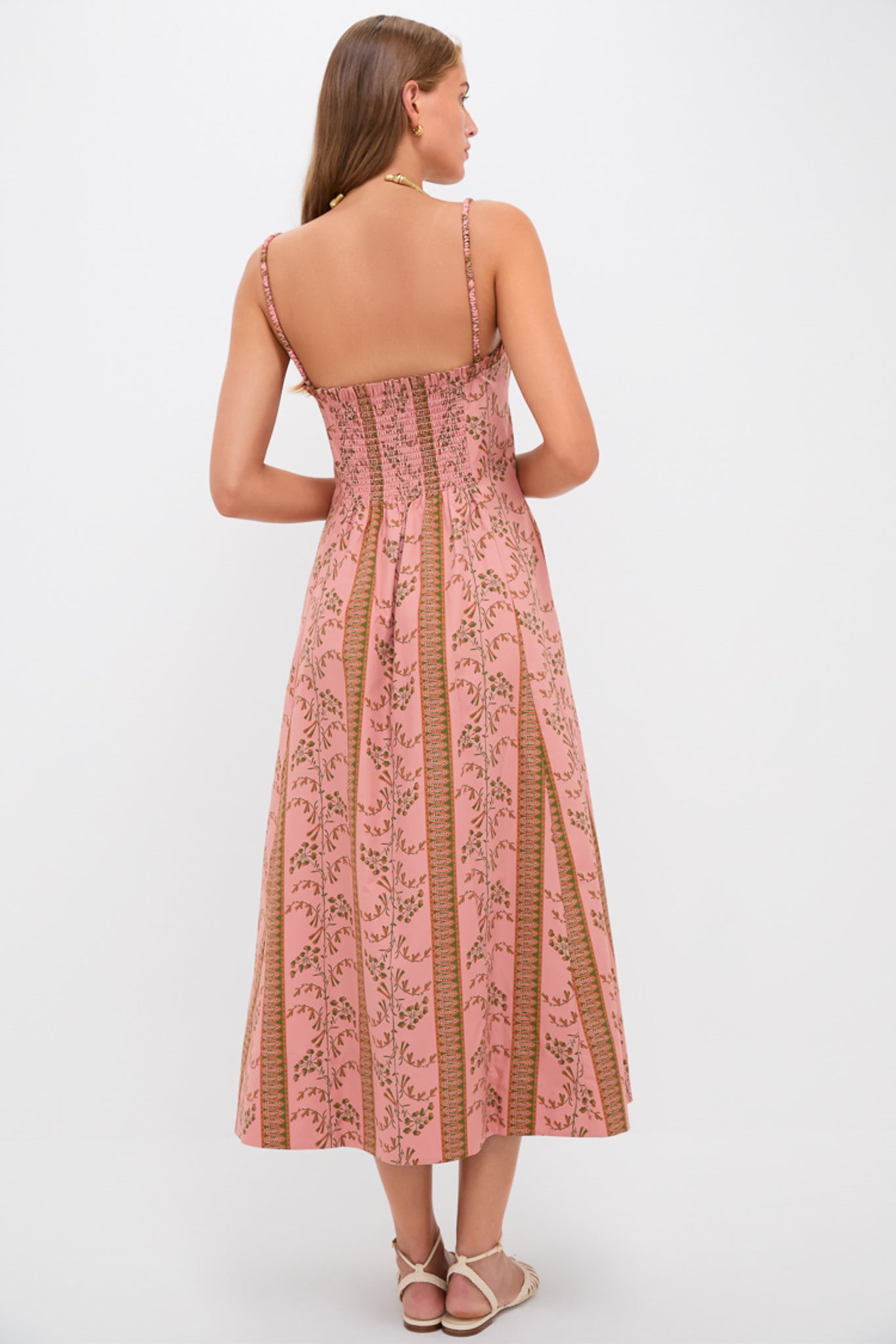 Woman in classic, effortless Rust Dandelion Floral Stripe Maisie Dress, featuring a ruched bodice and flowing skirt, embodying high-end, fun style with strappy sandals.