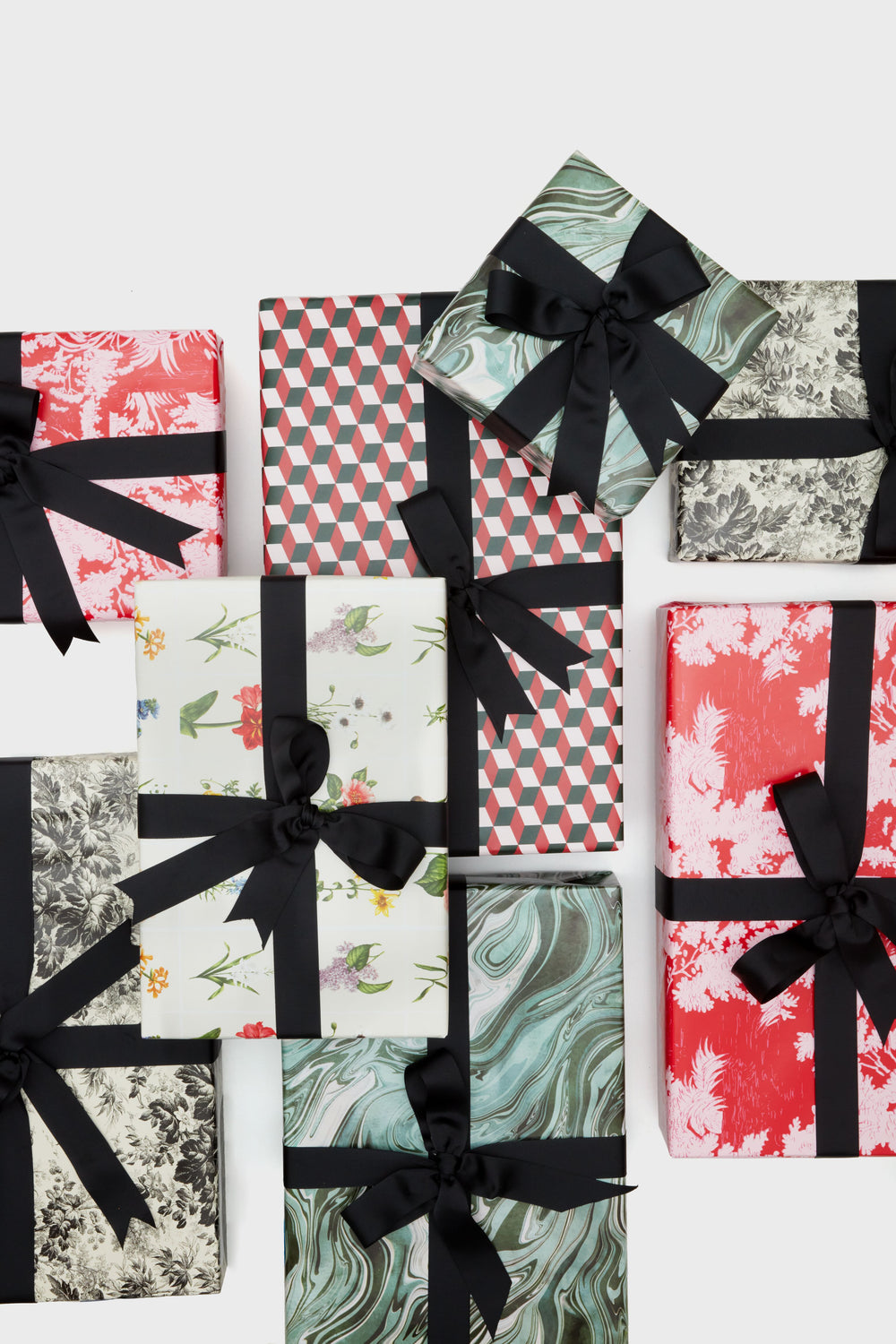 Stylishly arranged together, Supplies brand gift boxes feature various patterns and are neatly wrapped with black ribbon bows.