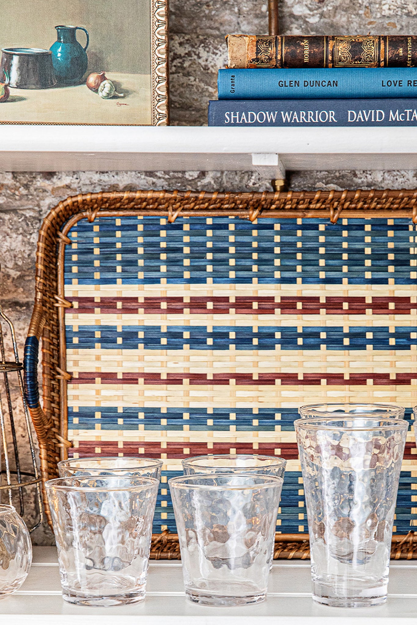 Navy Danish Stripe 18 Tray, handwoven with natural cane in classic neutral stripes, complements five hammered glasses, offering an effortless, high-end touch to any setting.