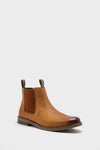 The Barbour Farsley Chelsea boot features tan leather, brown elastic side panels, green pull tabs, and a brown sole—ideal smart casual footwear for men.