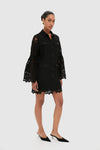 Black Lace Long Sleeve Rachael Mini Dress with intricate lace details, classic silhouette, and scalloped hem, styled effortlessly with kitten-heel mules for a fun, high-end look.