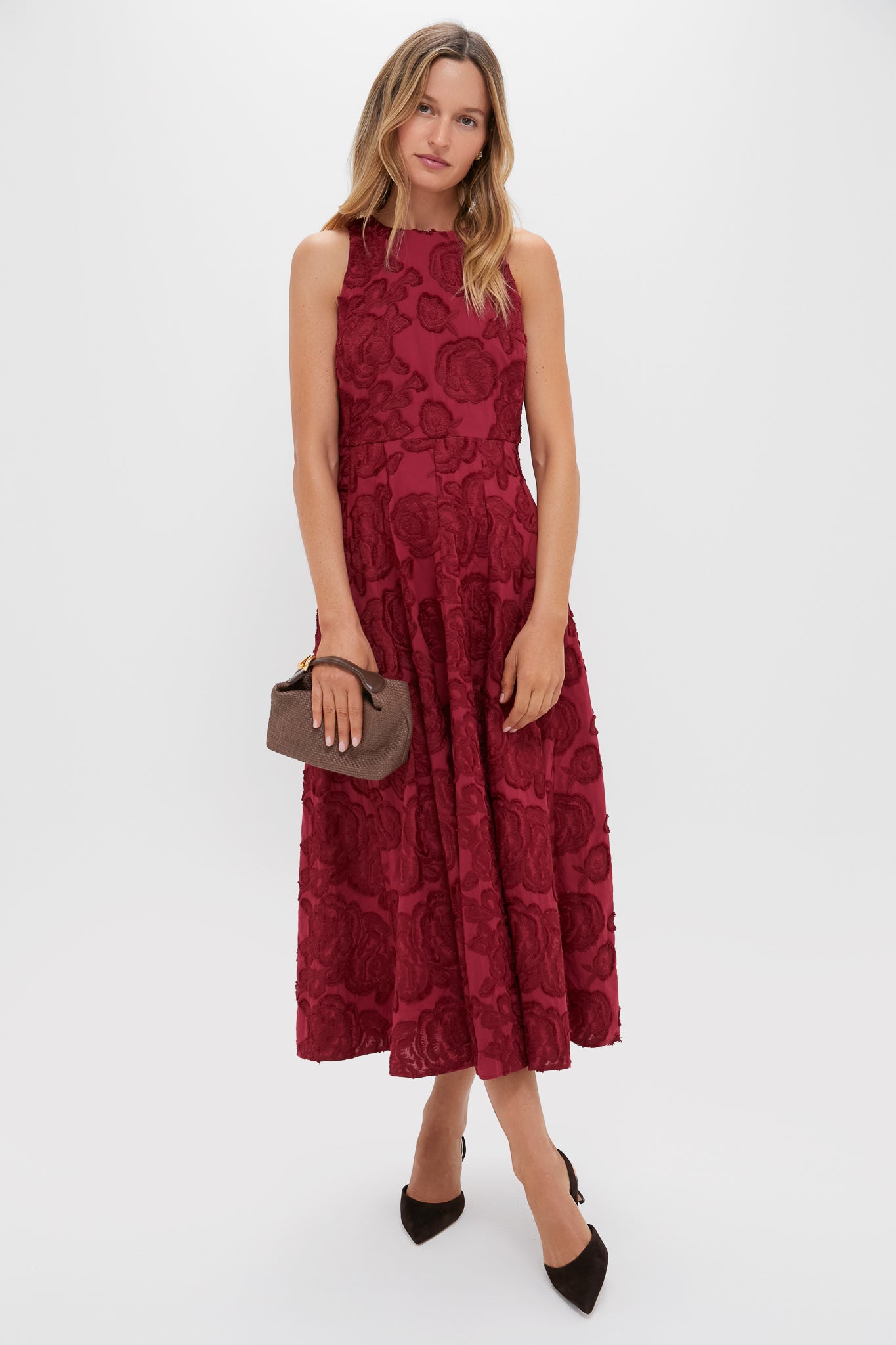 Ruby Textured Floral Melina Maxi Dress exudes classic elegance with its high-neck design and floral texture, effortlessly paired with a woven clutch and heels for a high-end look.