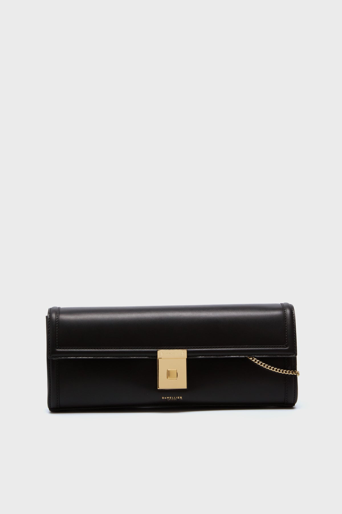 A rectangular black cowhide leather evening bag featuring a gold square clasp, gold chain detail, and Demellier logo at the bottom center.