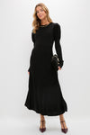 A woman in a black fit-and-flare maxi dress by Pomander Place.