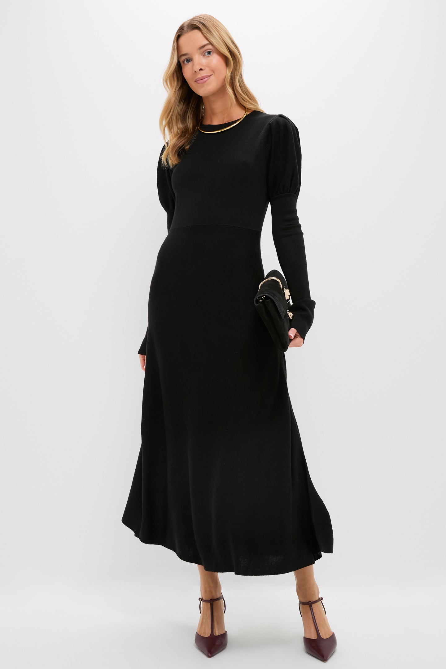 A woman in a black fit-and-flare maxi dress by Pomander Place.