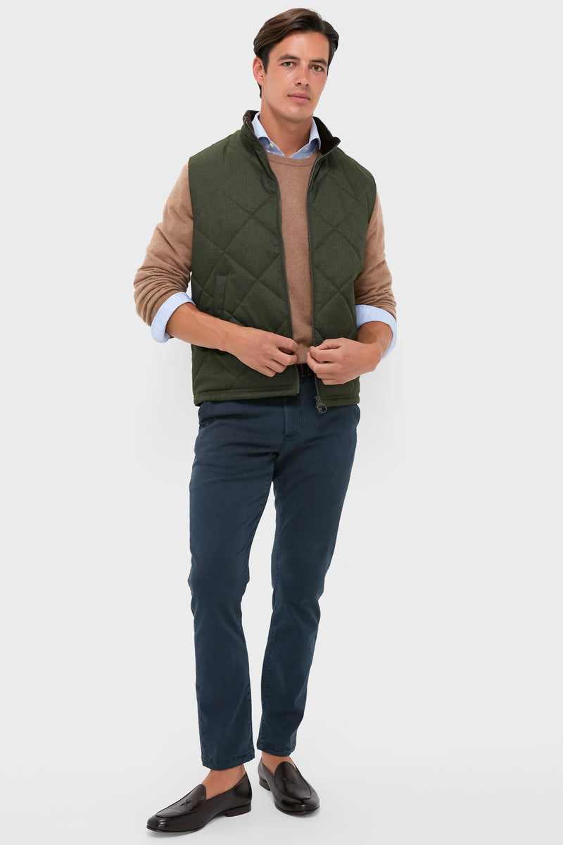 Model in classic olive Winter Finn Gilet, effortlessly styled with a light blue shirt, camel sweater, navy chinos, and brown loafers, showcasing high-end, fun fashion.