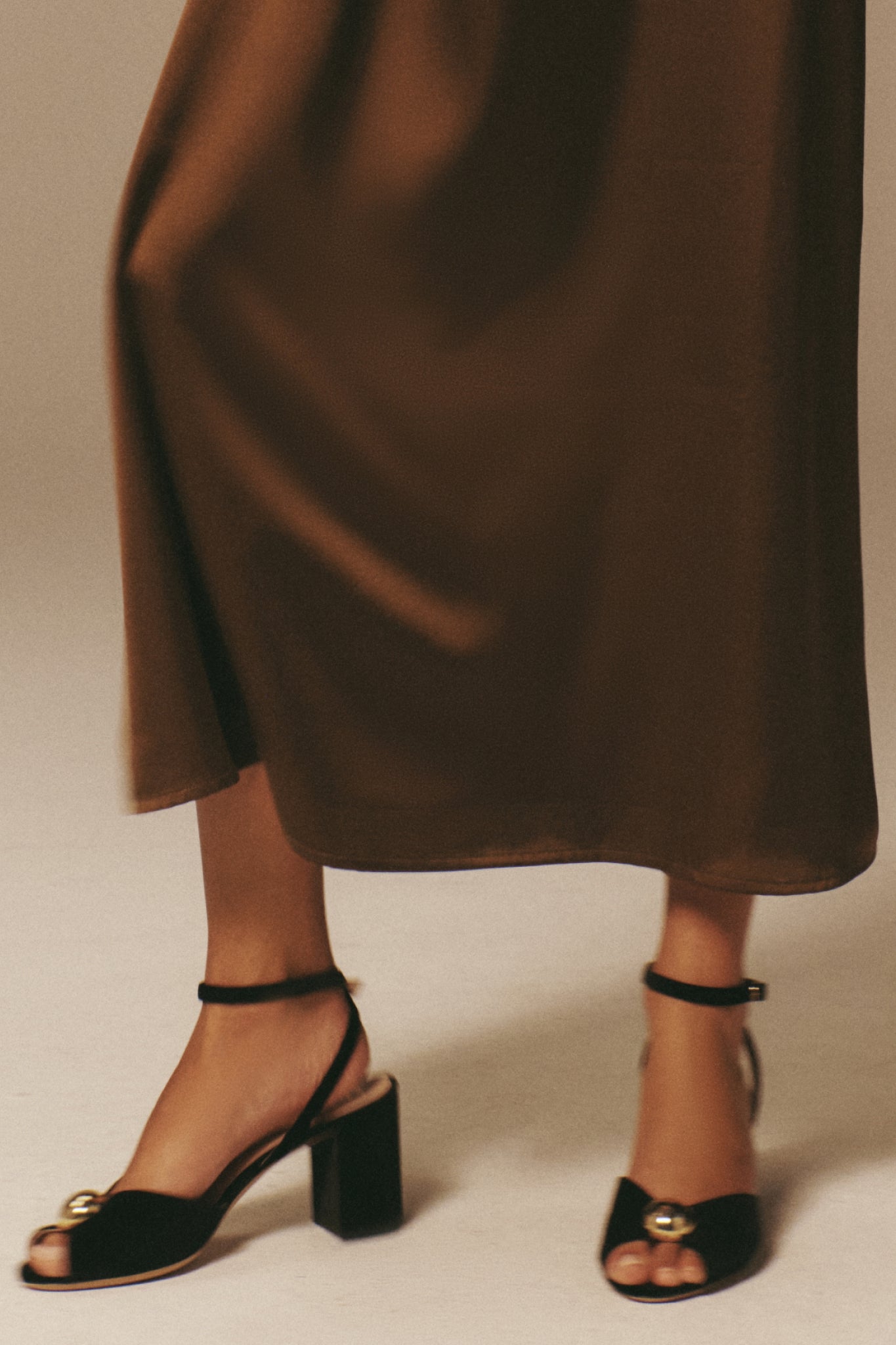 The Black Velvet Jewel Heel features a classic design with a gold ornament, block heel, and ankle strap, embodying effortless elegance for a high-end, fun style.