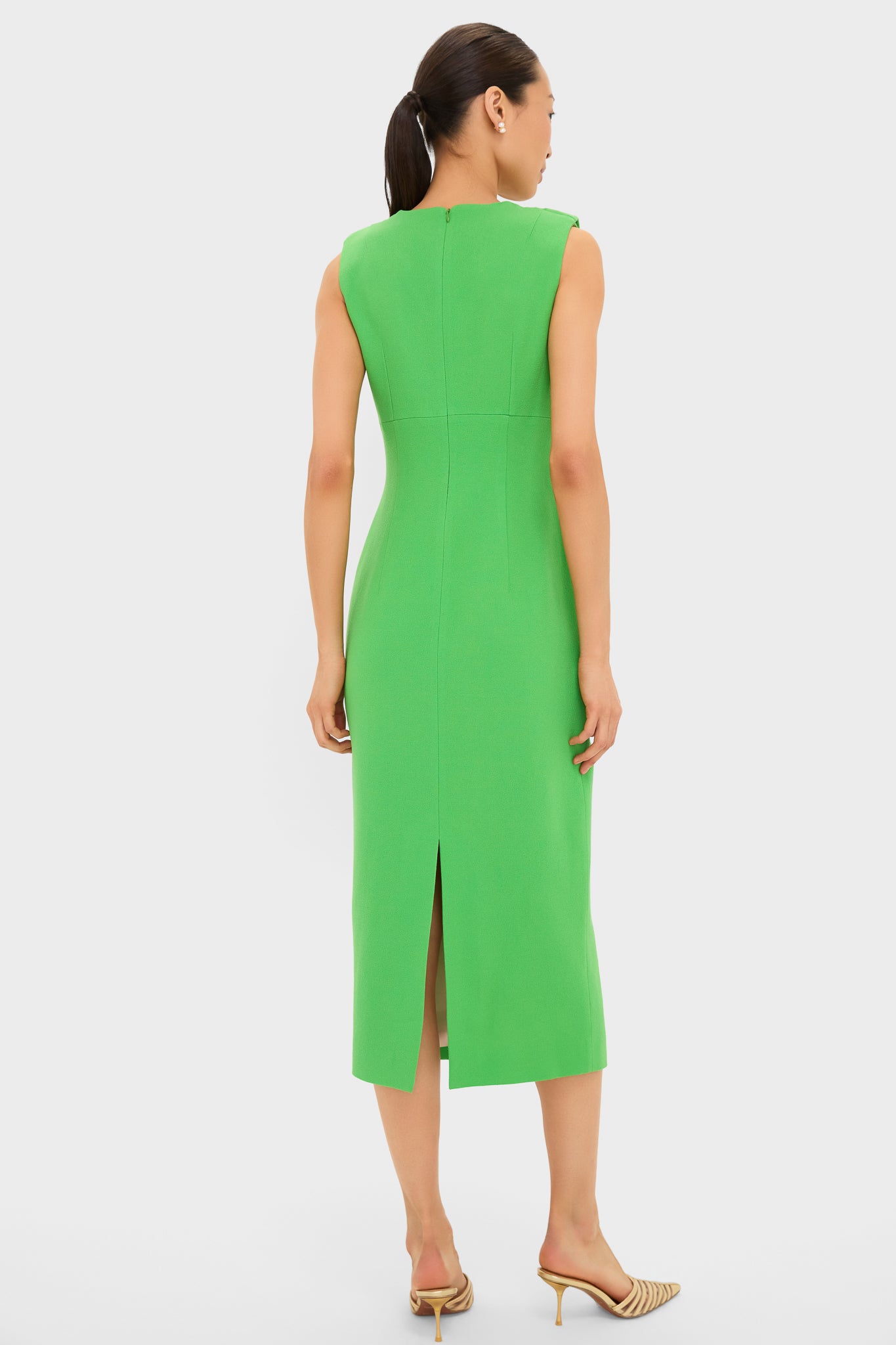 Woman in a classic, bright-green Fresh Green Yuri Gown with a sleek silhouette, dramatic neckline drapery, and strappy heels, embodying an effortless, fun, high-end style.