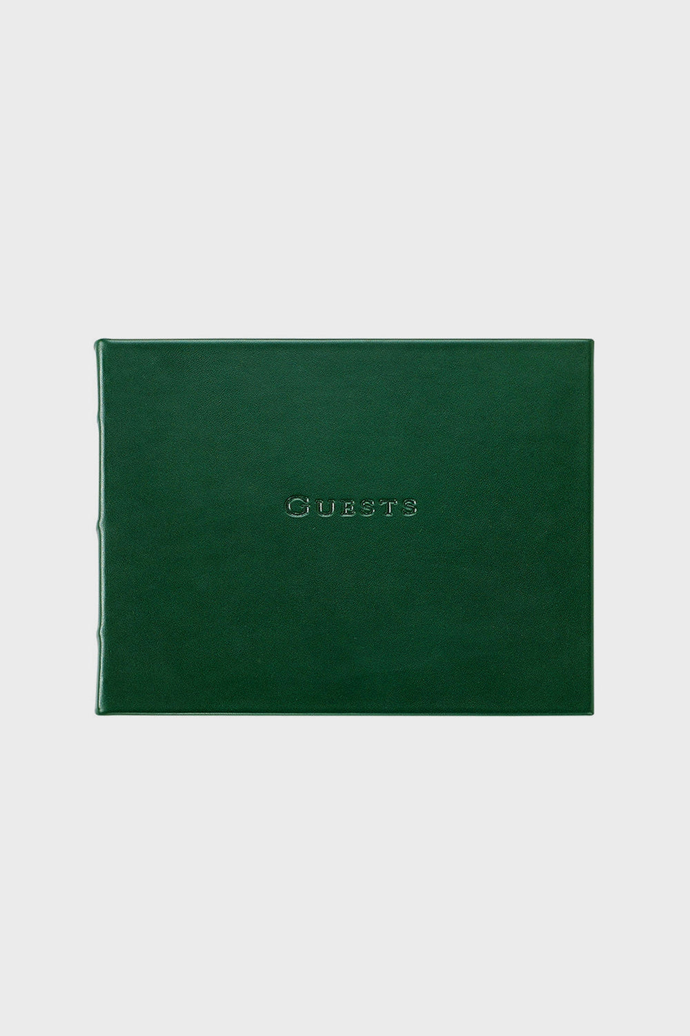 A closed, dark green leather guest book by Graphic Image with "Guests" embossed in uppercase on the front cover.