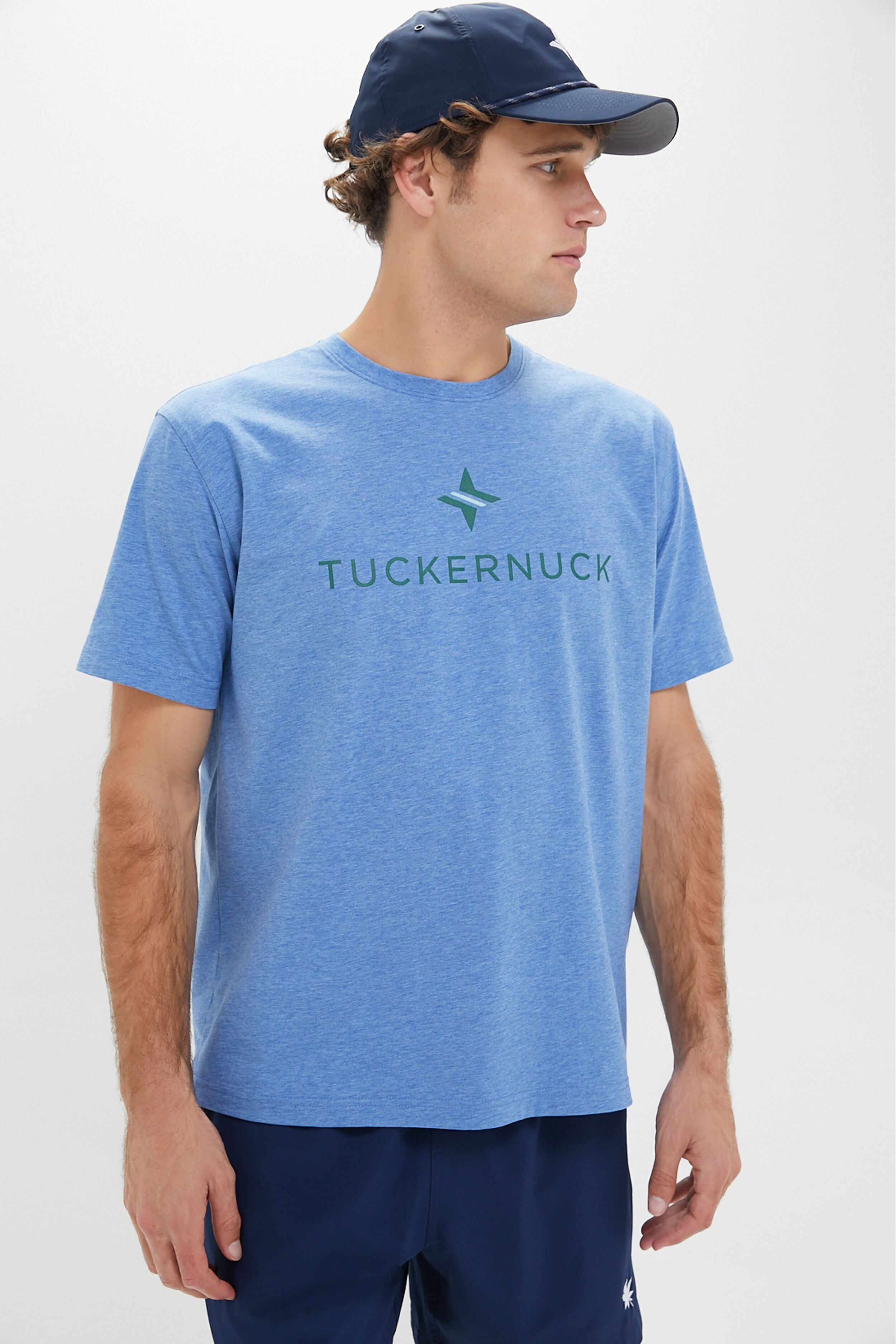 A man in a Nautilus Blue Peter Millar Tuckernuck Tee with UPF 50+ sun protection, navy shorts, and a navy cap looks to his right.