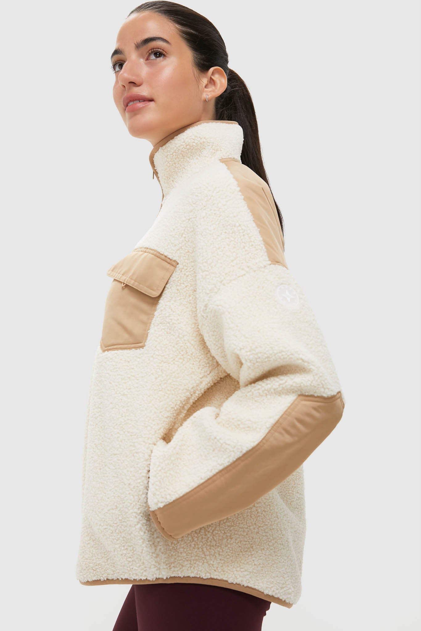 Classic and effortless, the Buttercream Fleece Lawrence Full Length Zip Up features a high-neck sherpa design with tan nylon accents, perfect for fun, high-end style.
