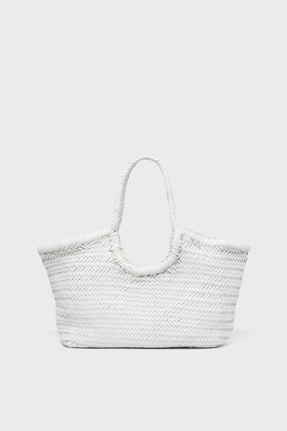 A white handwoven tote bag by Dragon Diffusion, featuring two handles, is displayed in a minimalist light gray setting.