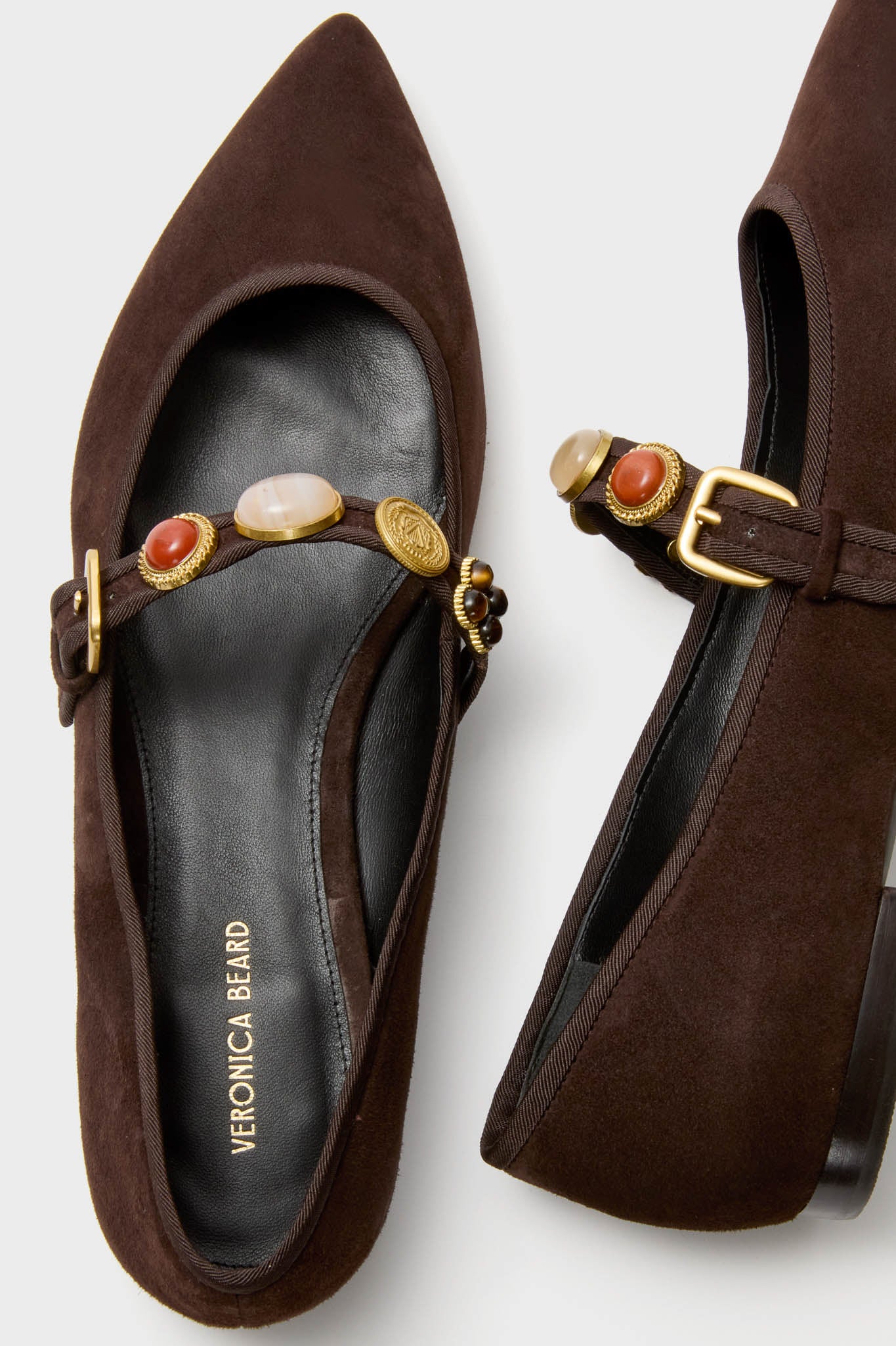 Espresso Selene Charms Flats feature a classic Mary-Jane design with pointed toes, an effortless gold-buckle strap, and fun boho-inspired charms for a high-end look.