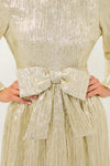 Gold Plisse Carol Bow Mini Dress, with a classic crinkled texture, fitted bodice, and bold bow, embodies effortless elegance and fun for high-end gatherings.