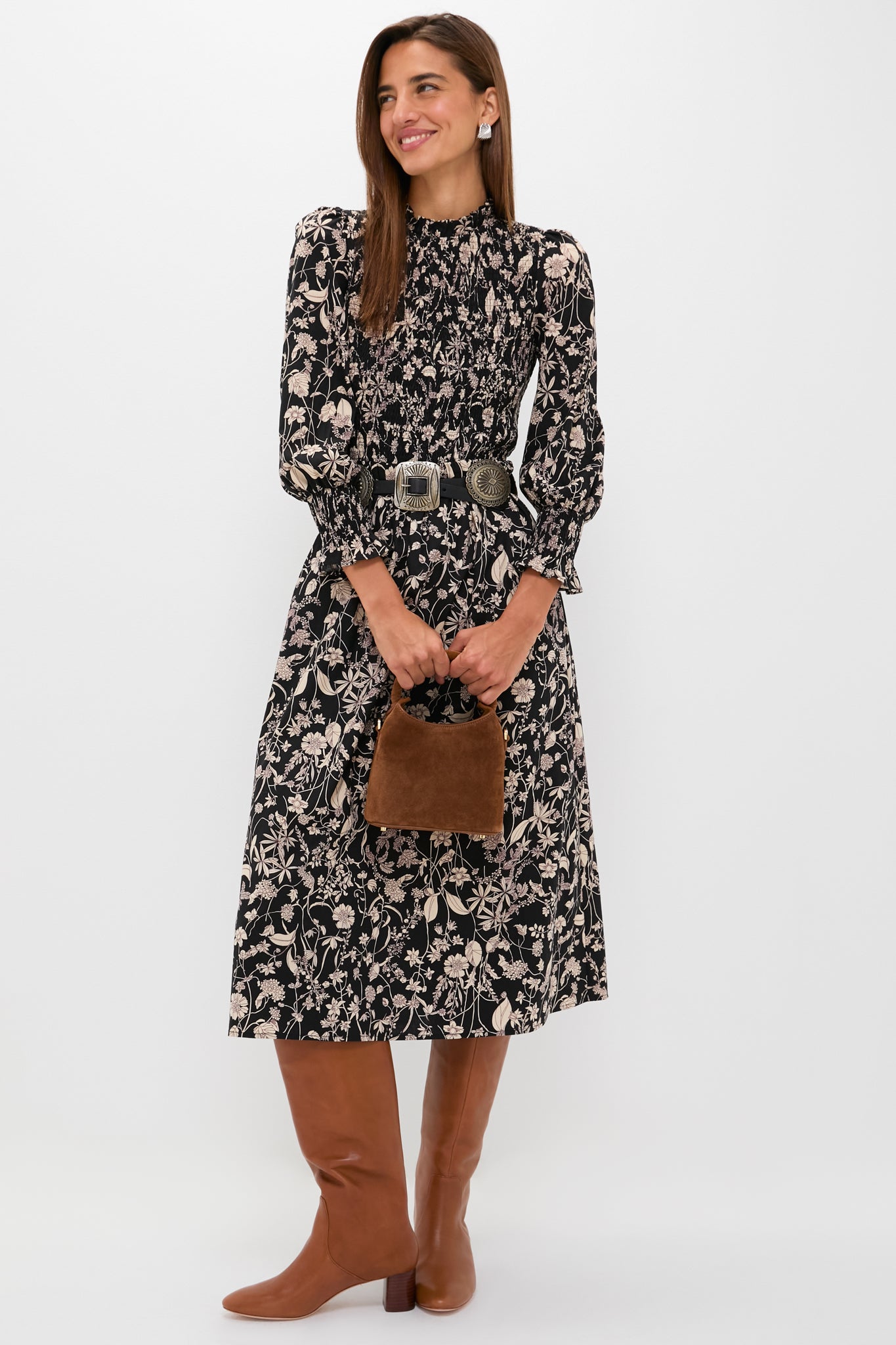 Woman models the Black & Tan Floral Smocked Susanne Midi Dress, featuring a classic, effortless silhouette with fun floral patterns and a high-end smocked bodice, styled with Western accessories.