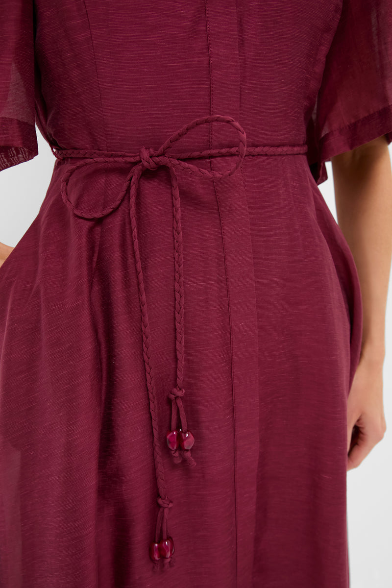Oxblood Cindy Midi Dress with braided rope belt and puff sleeves, elegantly cinched for a classic, effortless look, epitomizing high-end, fun fashion.